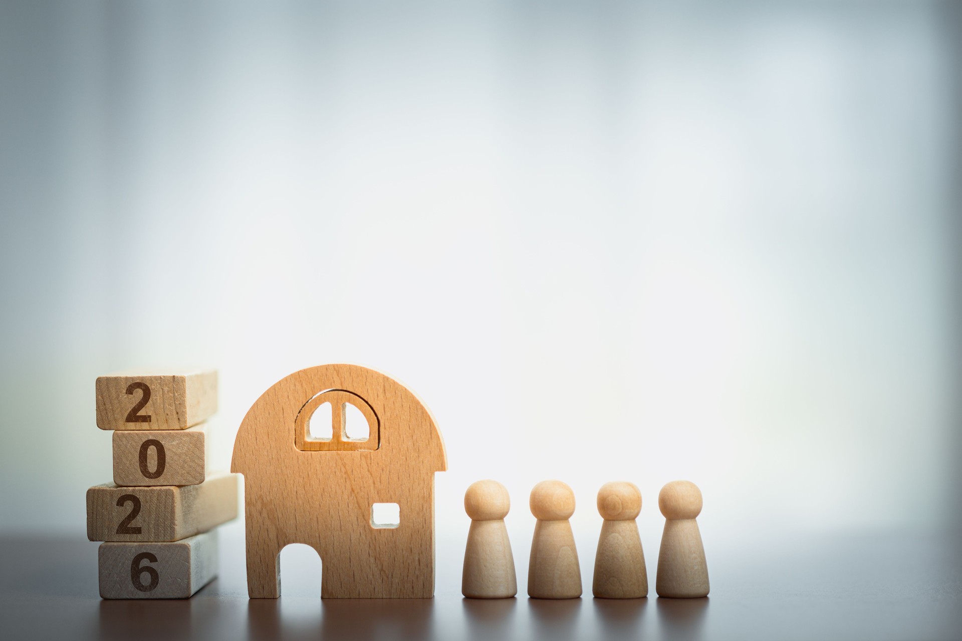 Wooden House with Peg Figures and 2026 Blocks, Symbolizing Home, Family, and Future Plans